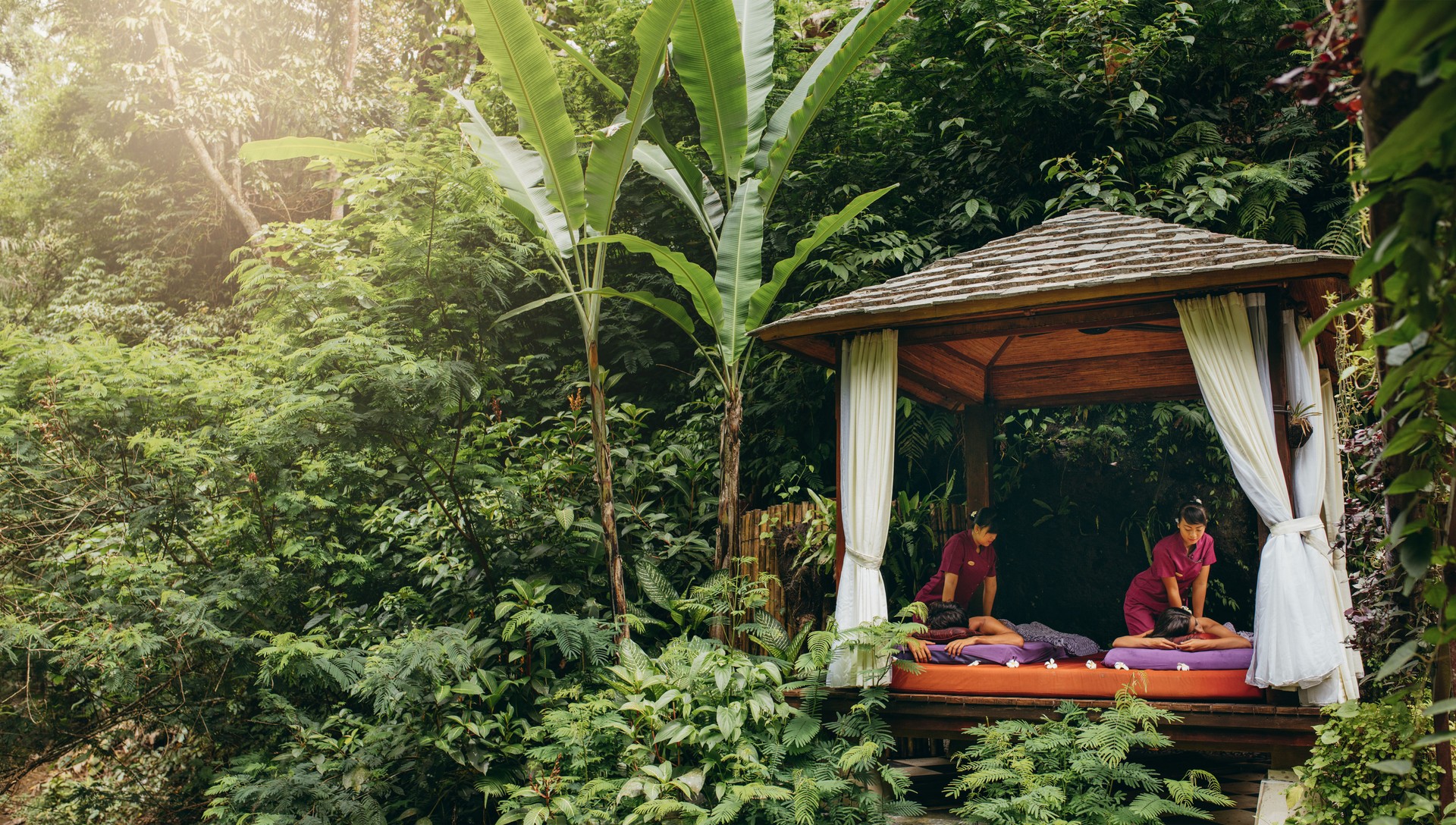 Massage pavilion in nature with couple receiving massage